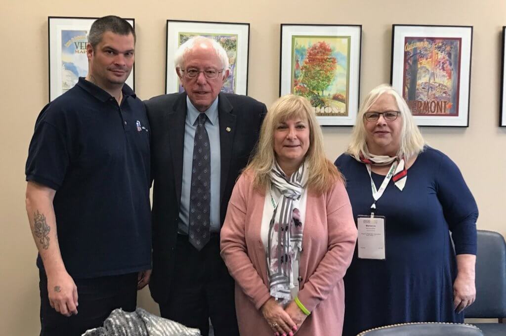 From left to right: Jay Isakson, Bernie Sanders, Deb Gass, and Marianne Miller stand together for a photo.