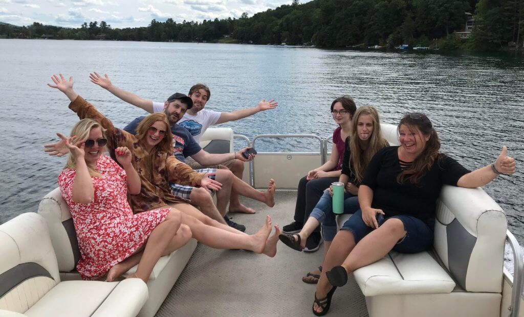 Staff strike a pose as they ride the pontoon boat across Lake Morey