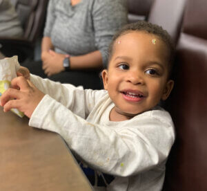little boy sitting at a table in a big conference chair