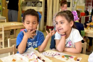 photo of two children enjoying samples of different veggies