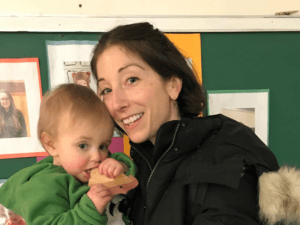 Image of a parent smiling while embracing a child